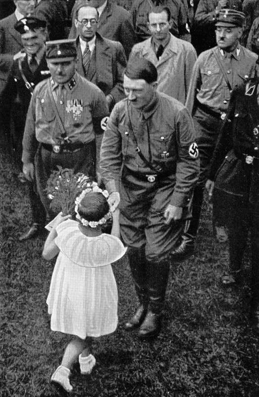A little girl offers a bouquet of flowers to Adolf Hitler on the occasion of Hitler's 44th birthday